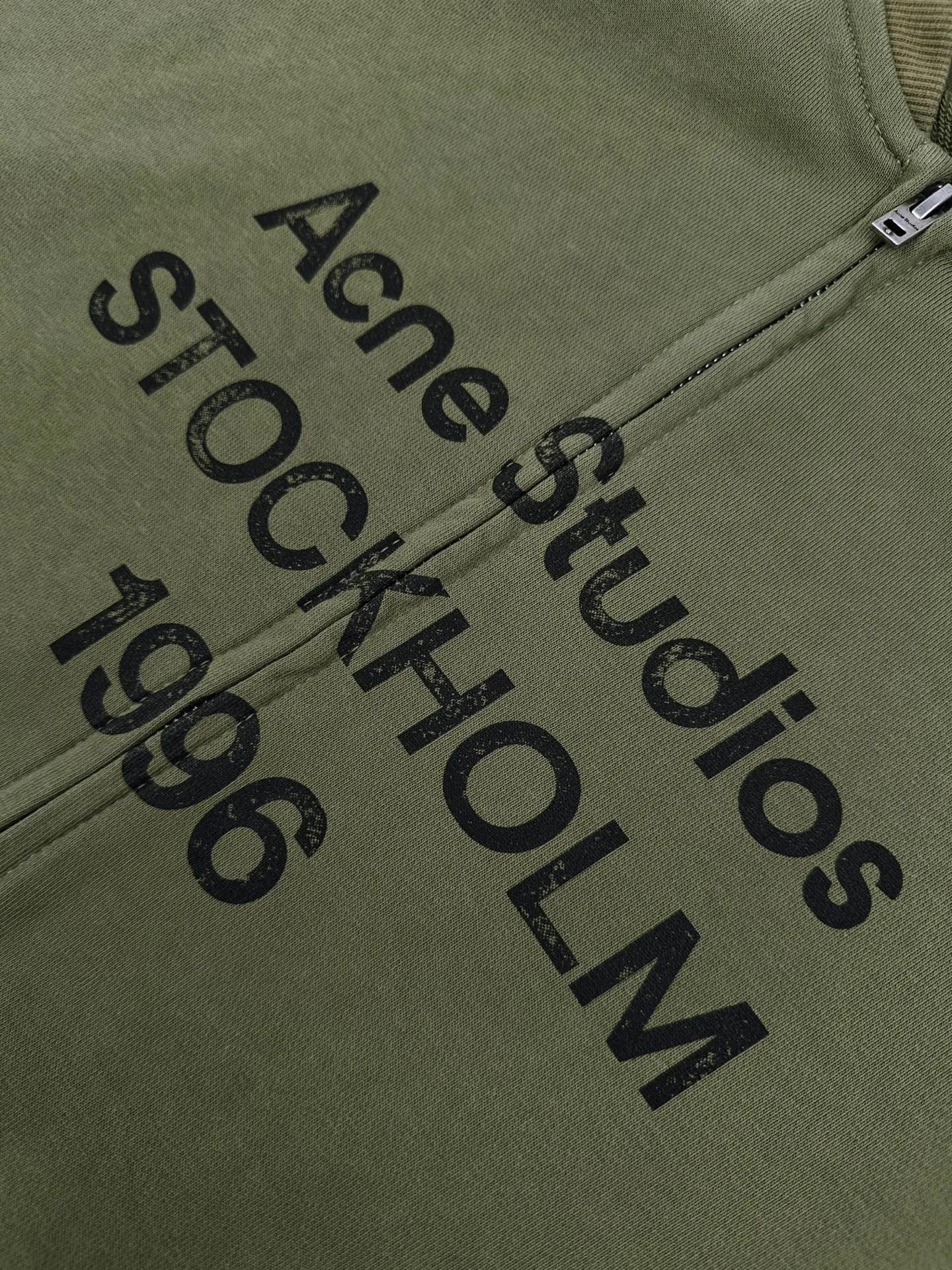 Acne Studios spray-painted distressed logo baseball collar jacket, custom-ordered soft velvet fleece cotton, crisp and smooth, skin-friendly and soft, olive green like mist between pine trees, matte matte surface flowing with warm and luxurious light, showing high-end restrained texture. Classic baseball collar zipper jacket has a neat and elegant silhouette, dropped shoulder tailoring for stretch and casualness, densely woven ribbing to show craftsmanship details, Acne Studios logo printing on the chest, engraving the brand heritage with Retro sports aesthetics Unobtrusive yet recognizable, it combines the Nordic minimalist style with the Retro sports style. It is low-key and elegant, with its own aura. Process 1: Using glue printing technology. The chest printing has been modified three times with the film screen. Use glue liquid paint to print the pattern on the fabric. Bake the fabric to fix the printed pattern. Technique 2: Gradient distressed spray-on process. By spraying dyes of different colors on the surface of the fabric, the clothes can show rich color changes under different lights and increase the visual layering. Process 3: Many parts of the body of the garment are worn by pure manual regular positioning and manual brushing. Texture and depth are added to the surface of the clothing to imitate the texture of natural wear. Process 4: The fabrics are fermented and washed for a better hand feel. Not easy to deform, not easy to shrink, not easy to fade, and maintain long-term beauty. Accessories: Customized 1:1 Acne zipper Customized 1:1 Acne trademark Version: Loose version Size: S M L XL Style number: CC